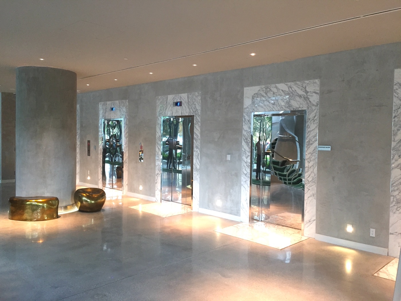 Polished concrete floor in a high-end commercial lobby with marble and elevators